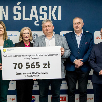 Grzegorz Boski, wicemarszałek województwa, wręcza symboliczne czeki przed Stadionem Śląskim. (wygenerowano przez AI)