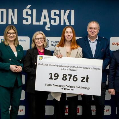 Grzegorz Boski, wicemarszałek województwa, wręcza symboliczne czeki przed Stadionem Śląskim. (wygenerowano przez AI)