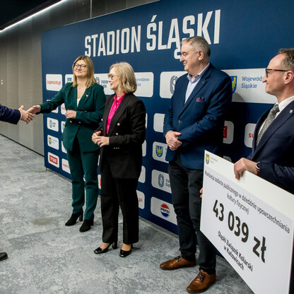Grzegorz Boski, wicemarszałek, wręcza symboliczne czeki na Stadionie Śląskim. (wygenerowano przez AI)