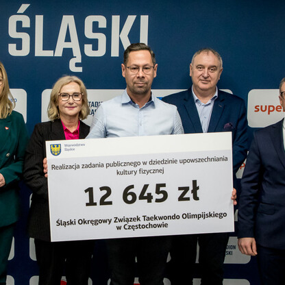 Grzegorz Boski, wicemarszałek, wręcza symboliczne czeki na Stadionie Śląskim. (wygenerowano przez AI)