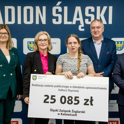 Grzegorz Boski, wicemarszałek województwa, prezentuje symboliczny przelew na Stadionie Śląskim. (wygenerowano przez AI)
