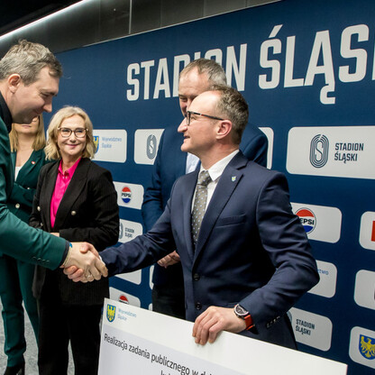 Grzegorz Boski, wicemarszałek, wręcza symboliczne czeki na Stadionie Śląskim. (wygenerowano przez AI)