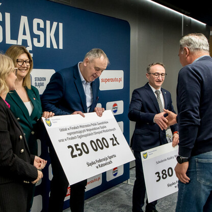 Grzegorz Boski, wicemarszałek, wręcza symboliczne czeki na Stadionie Śląskim. (wygenerowano przez AI)
