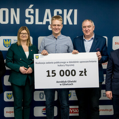 Grzegorz Boski, wicemarszałek, wręcza symboliczne czeki przedstawicielom organizacji na Stadionie Śląskim. (wygenerowano przez AI)