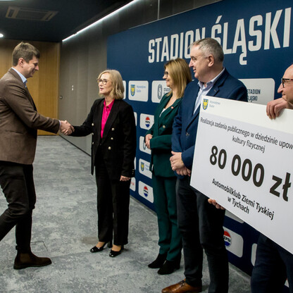 Grzegorz Boski, wicemarszałek Województwa Śląskiego, prezentuje symboliczne czeki na Stadionie Śląskim. (wygenerowano przez AI)
