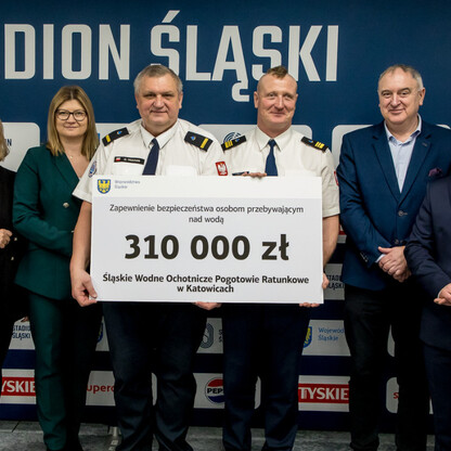 Grzegorz Boski, wicemarszałek, wręcza symboliczne czeki na Stadionie Śląskim. (wygenerowano przez AI)