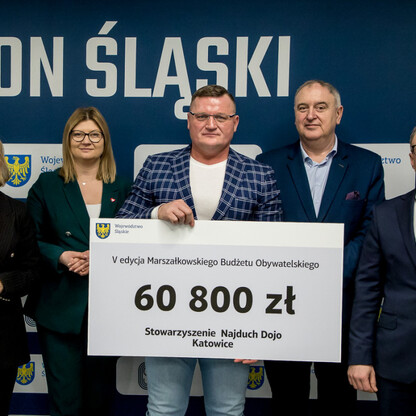 Grzegorz Boski, wicemarszałek Województwa Śląskiego, wręcza symboliczne czeki na Stadionie Śląskim. (wygenerowano przez AI)