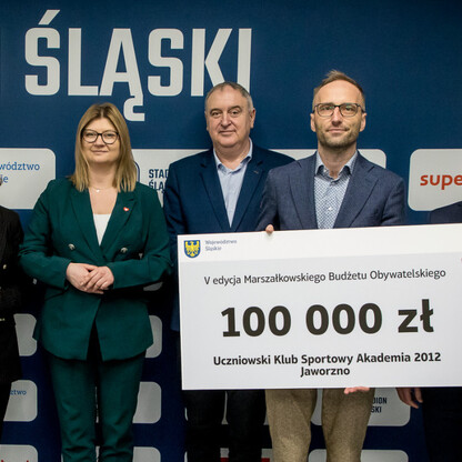 Grzegorz Boski, wicemarszałek, wręcza symboliczne czeki na Stadionie Śląskim. (wygenerowano przez AI)