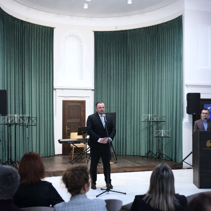 Wnętrze nowo otwartego spinPLACE, centrum kreatywności i coworkingu, z widocznym logo i zasiadającymi na scenie osobami. (wygenerowano przez AI)