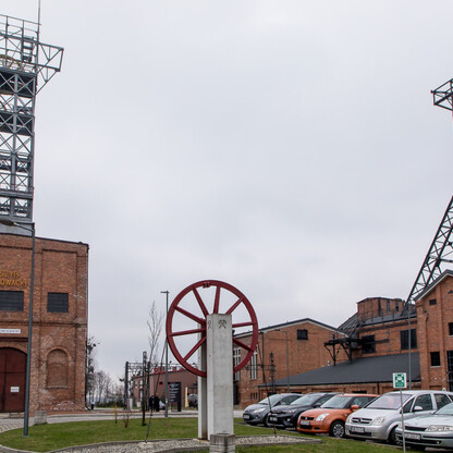 Historiczna kopalnia Ignacy w Rybniku, zabytek przemysłowy z czerwonymi budynkami i dwoma wieżami, symbolizuje bogate przeszłość górniczą regionu. (wygenerowano przez AI)