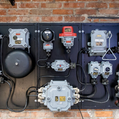 Elektryczna deska sterowania złożona z różnych przycisków i przewodów, umieszczona na ceglanej ścianie, związana z Zabytkową Kopalnią Ignacy w Rybniku, Polska. (wygenerowano przez AI)