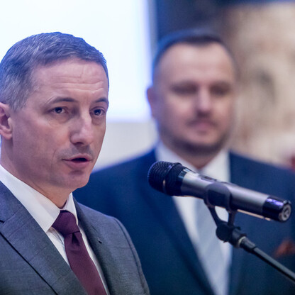 Mężczyzna w garniturze przemawia do mikrofonu, podczas konferencji prasowej w Silesia. (wygenerowano przez AI)