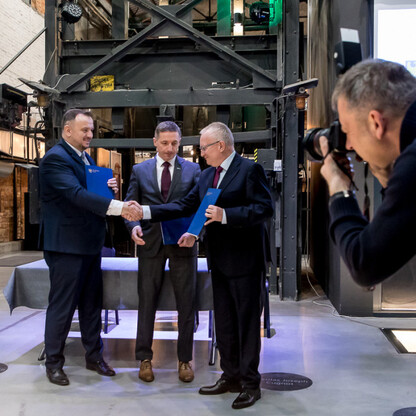 Trzech mężczyzn w formalnym stroju biznesowym podpisuje umowę o zarządzaniu kopalnią w Zabytkowej Kopalni Ignacy w Rybniku, Śląsk. (wygenerowano przez AI)