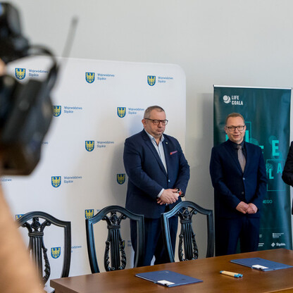 W trakcie konferencji prasowej w Silesia, trzech mężczyzn w garniturach omawiają plany adaptacji do zmian klimatu. (wygenerowano przez AI)