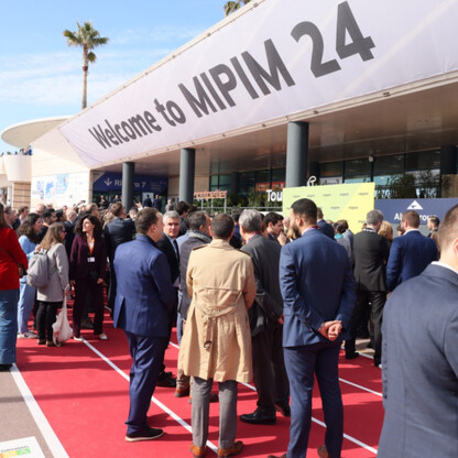 Widoczna jest scena otwarcia MIPIM 24 w Cannes, gdzie tłum zgromadzony na czerwonym dywanie przed wejściem do sali. (wygenerowano przez AI)