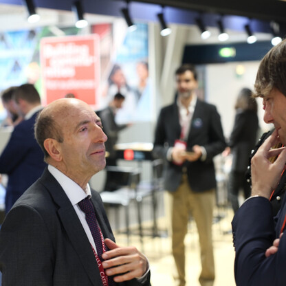Mężczyźni w garniturach omawiają strategię inwestycji na MIPIM w Cannes. (wygenerowano przez AI)