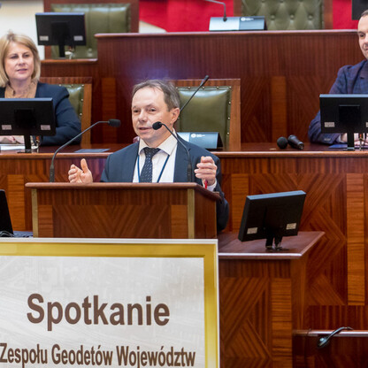 Formalna sesja w Katowicach, uczestniczą geodetowie i wicemarszałek, omawiają doświadczenia w geodezji. (wygenerowano przez AI)