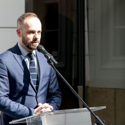 Członek Zarządu Województwa Śląskiego Grzegorz Boski przemawia na ceremonii symbolicznego przekazania funduszy na modernizację dróg dojazdowych do gruntów rolnych w południowej części województwa śląs (wygenerowano przez AI)
