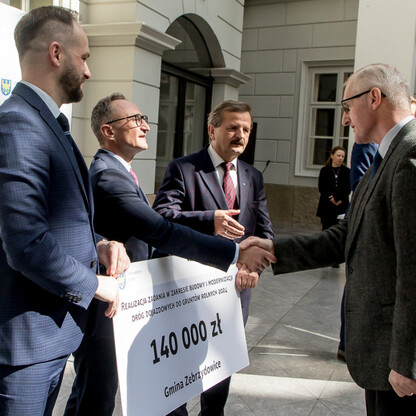 Grzegorz Boski, wicemarszałek województwa śląskiego, przekazuje symboliczne czeki na modernizację dróg dojazdowych do gruntów rolnych w Bielsku-Białej. (wygenerowano przez AI)