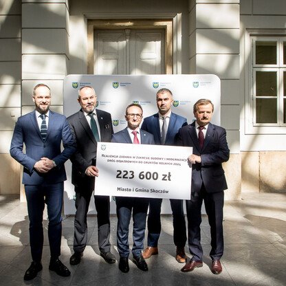 Grzegorz Boski, wicemarszałek województwa śląskiego, przekazuje symboliczne czeki na modernizację dróg dojazdowych do gruntów rolnych. (wygenerowano przez AI)