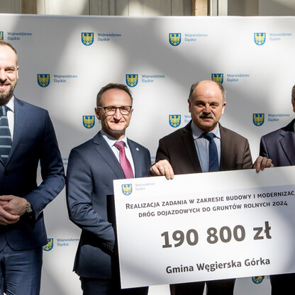 Grzegorz Boski, wicemarszałek województwa śląskiego, prezentuje symboliczny czek na modernizację dróg dojazdowych do gruntów rolnych. (wygenerowano przez AI)