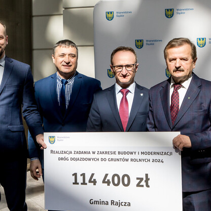 Grzegorz Boski, wicemarszałek województwa, prezentuje symboliczny czek na modernizację dróg dojazdowych do gruntów rolnych w Gminie Rajcza. (wygenerowano przez AI)