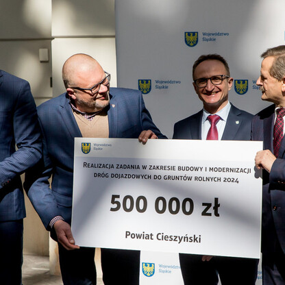 Grzegorz Boski, wicemarszałek województwa, podczas przekazania symbolicznego czeku na modernizację dróg dojazdowych do gruntów rolnych w Cieszynie. (wygenerowano przez AI)