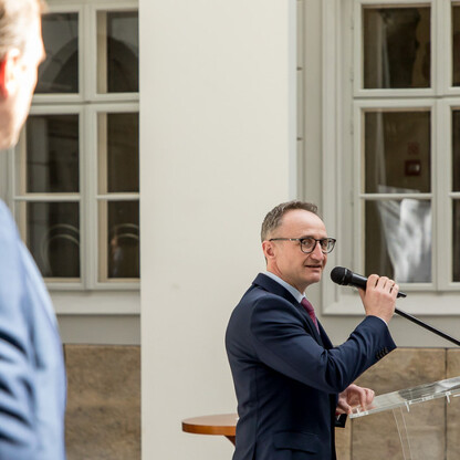 Grzegorz Boski, wicemarszałek województwa śląskiego, przemawia na podium podczas ceremonii przekazania funduszy na rozwój dróg dojazdowych do gruntów rolnych w Bielsku-Białej. (wygenerowano przez AI)